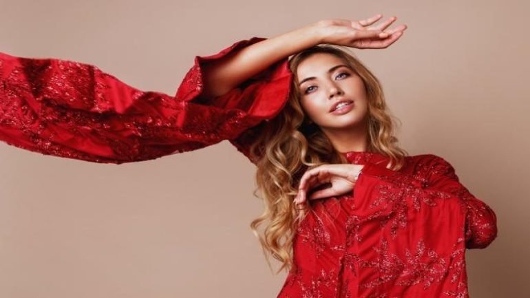 seductive-blonde-woman-posing-luxury-red-dress-with-wide-sleeves-fashionable-look-blond-wavy-hairs-expressive-photo-windy-cloth.jpg